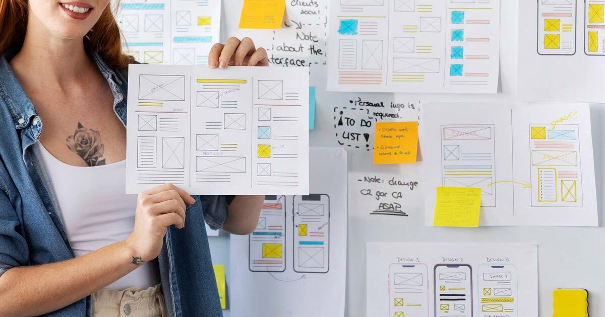 Developers implementing a UX design into a responsive web interface with code and design tools on screen